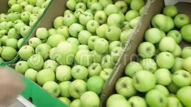 超市里的女孩选择绿色苹果。 女手在超市选购青苹果.. 一大堆
